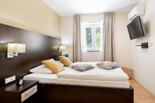 a bedroom with a bed with white sheets and a television at Ponent 602 in Marina Portorož by Locap Group in Portorož