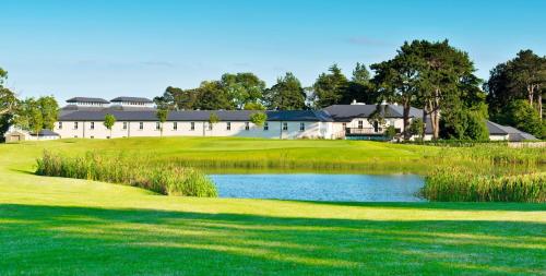 a golf course with a pond in front of a building at Roganstown Hotel & Country Club in Swords