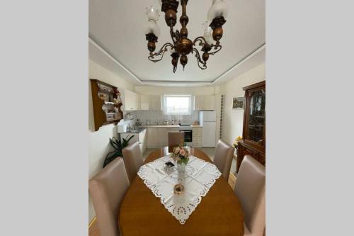 a dining room with a table and a chandelier at Stan na dan Oplenac in Topola