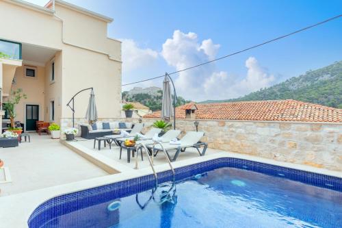 a villa with a swimming pool and a house at Apartments Ante in Hvar