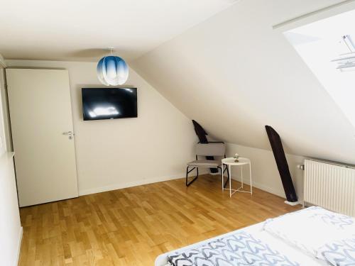 a bedroom with a bed and a tv on the wall at aday - City Central Mansion - 4 bedroom apartment in Aalborg