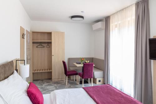 a hotel room with a bed and a table and chairs at Gasthof "zur Bahn" in Lassnitzhöhe