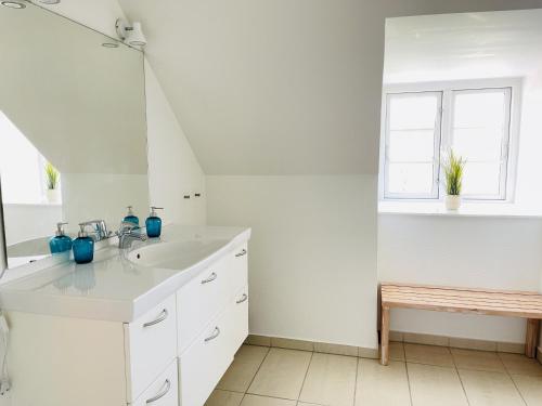 a white bathroom with a sink and a window at aday - City Central Mansion - 4 bedroom apartment in Aalborg