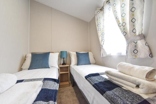 two beds in a small room with a window at Hope View at Ashbourne Heights in Ashbourne