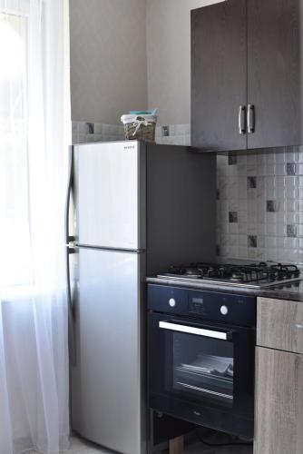 kuchnia z białą lodówką i kuchenką w obiekcie Apartment Amest w mieście Batumi