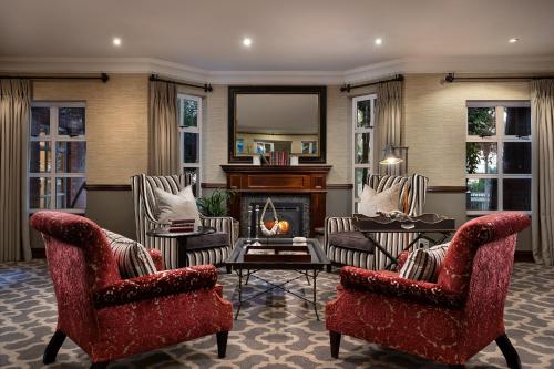 a living room with two chairs and a fireplace at Premier Hotel Quatermain in Johannesburg