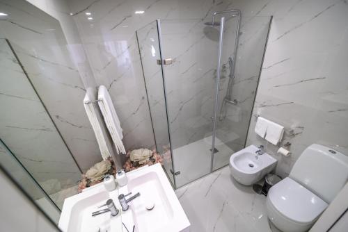 a bathroom with a shower and a sink and a toilet at FERREIRA'S HOUSE Guimarães in Guimarães