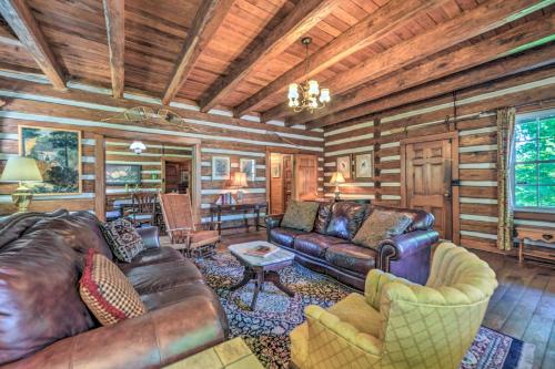 a living room with leather furniture in a log cabin at Rustic Dover Retreat with Porch - Walk to Boat Ramp! in Dover