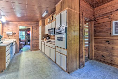 a kitchen with wooden walls and counters and a stove at Rustic Dover Retreat with Porch - Walk to Boat Ramp! in Dover