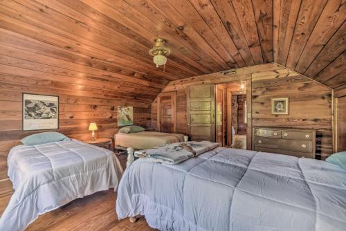 a bedroom with two beds in a wooden cabin at Rustic Dover Retreat with Porch - Walk to Boat Ramp! in Dover