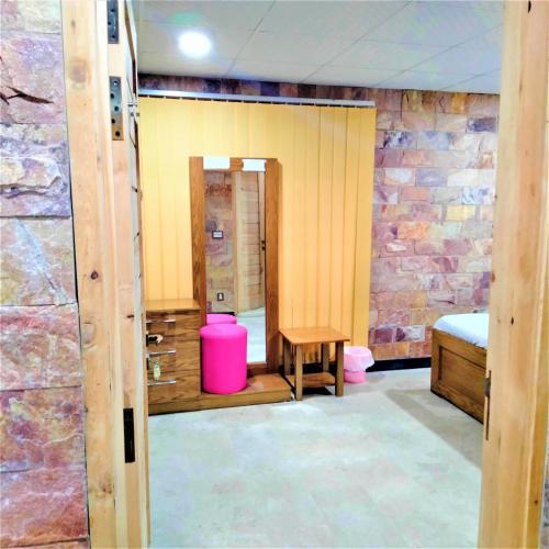 a room with a stone wall and a bed and a table at Hotel Vista Inn DHA in Rawalpindi