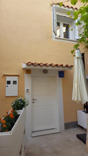 a building with a white door and a window at Apartments Padre **** in Baška