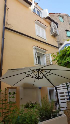 a large umbrella in front of a building at Apartments Padre **** in Baška