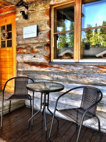 two chairs and a table in front of a building at Ruka Chalet Charmant Oliver in Ruka