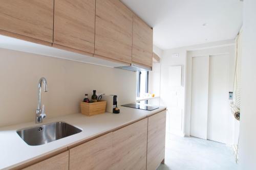 a kitchen with wooden cabinets and a sink at Aeris Boutique Studio in Girona