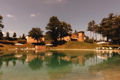 a large pool of water in front of a house at Agriturismo San Galgano in Chiusdino