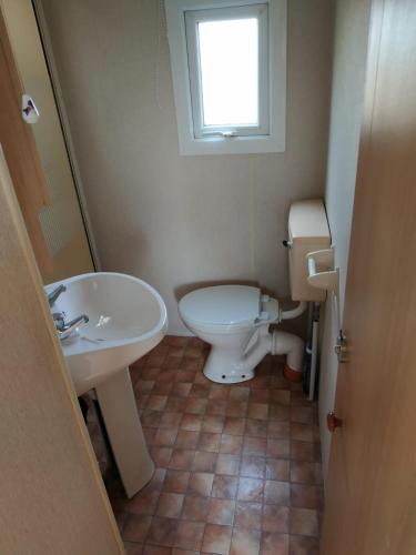 a bathroom with a white toilet and a sink at 4U Pokój w domku holenderskim Rooms in Tinyhouse in Zgorzelec