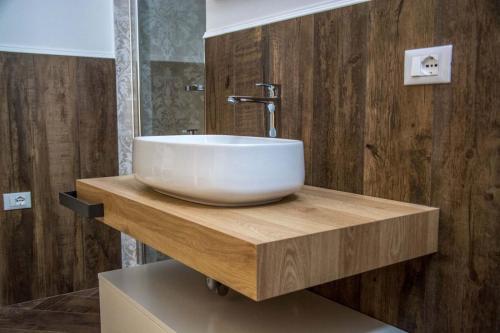 uma casa de banho com um lavatório branco num balcão de madeira em B&B Martina em Mirabella Eclano