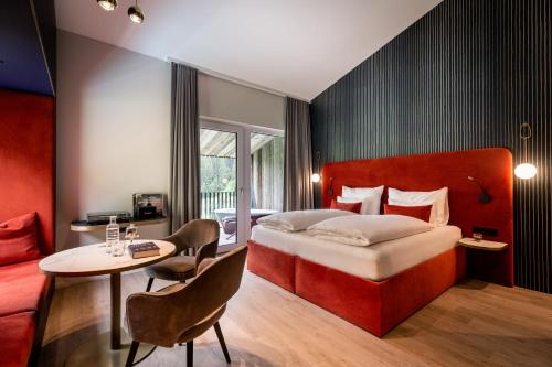 ザールバッハ・ヒンターグレムにあるGoldstück - Adults Onlyのベッドとテーブルが備わるホテルルームです。