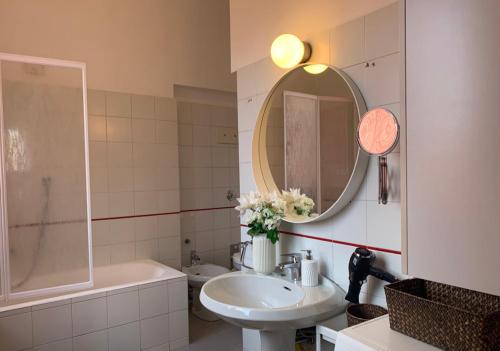 W łazience znajduje się umywalka, lustro i wanna. w obiekcie Camozzi Central Apartment w Bergamo