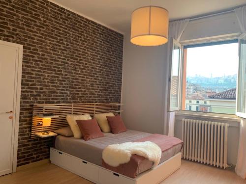 sypialnia z łóżkiem i ścianą z cegły w obiekcie Camozzi Central Apartment w Bergamo