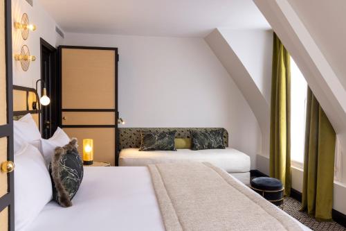 a hotel room with two beds and a window at Grand Hôtel Chicago in Paris
