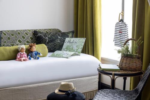 two dolls sitting on a couch in a living room at Grand Hôtel Chicago in Paris