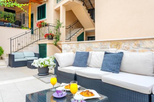 a patio with a white couch and a table at Apartments Ante in Hvar