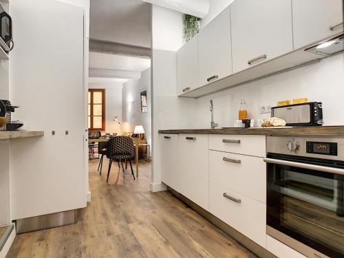 a kitchen with white cabinets and a counter top at Coeur Vieux Nice - Place Rossetti in Nice