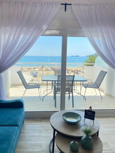 a living room with a table and a view of the ocean at Ifigenia Sea View Apartments in Chrysi Ammoudia