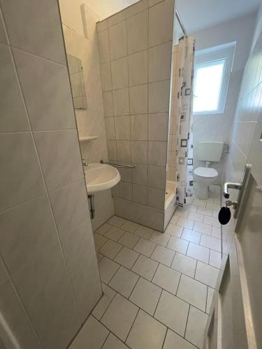 a bathroom with a shower and a sink and a toilet at Pension Der Kretaner in Berlin