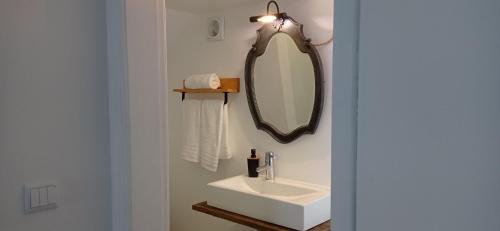 a bathroom with a sink and a mirror at Pipo People House in Óbidos