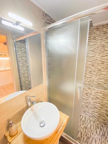 a bathroom with a sink and a shower at Ifigenia Sea View Apartments in Chrysi Ammoudia