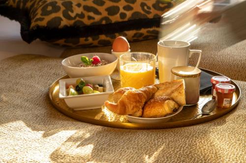 a tray with breakfast foods and drinks on a table at Grand Hôtel Chicago in Paris