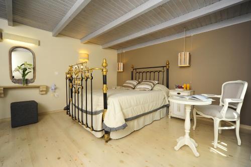 een slaapkamer met een bed, een bureau en een stoel bij Mythos Suites Boutique Hotel in Rethimnon