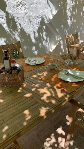 a wooden table with plates and glasses on it at Agroturismo Rafal Rubí in Alaior