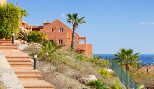ein Haus am Strand mit Treppen und Palmen in der Unterkunft Lagos de Santa María Luxury Apartment Isabel in Marbella