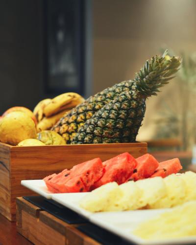 a plate of fruit on a table with a pineapple at Gandini Hotel in Itu