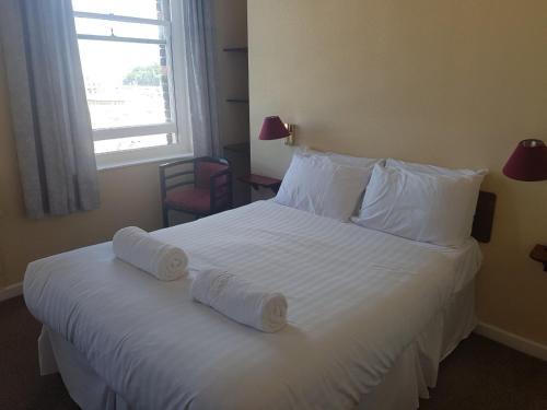 a hotel room with a bed with two towels on it at The Fairhaven Hotel in Weymouth