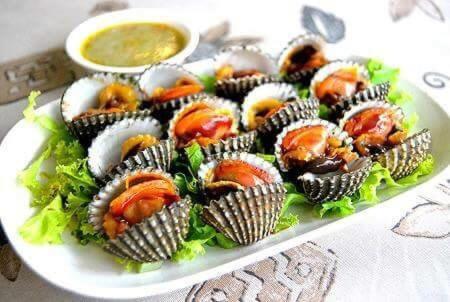 a plate of food with oysters and dipping sauce at Rimlay Bungalow in Nai Yang Beach