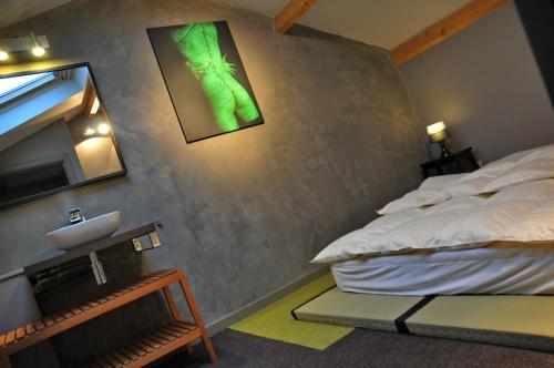 a bedroom with a bed and a green picture on the wall at Gite Ard'zen in Noiseux