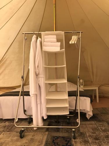 a clothes rack in a tent with clothes at Rum og rooms in Brundby