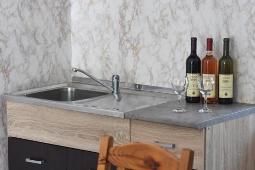 two bottles and two glasses of wine on a counter at Village house Borozan in Cetinje