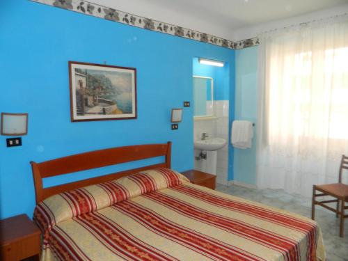 a bedroom with a bed and a blue wall at Roxena house in Rome