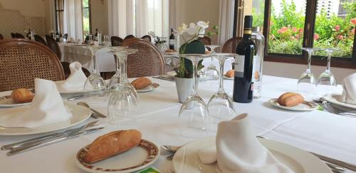 a table with white plates and wine glasses and bread at Hotel Zarauz in Zarautz