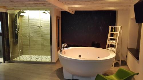 a bathroom with a large tub and a glass shower at La estrella del viajero in Casas del Abad