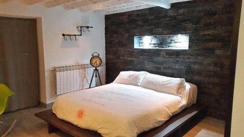 a bed in a room with a brick wall at La estrella del viajero in Casas del Abad