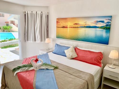 1 dormitorio con 1 cama con una pintura en la pared en Beautiful family Villa near Bavaro beach with pool, en Punta Cana