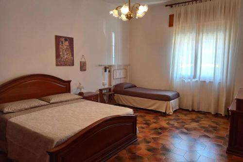 a bedroom with a bed and a chair in it at La Terrazza sul Melograno - Magomadas in Magomadas