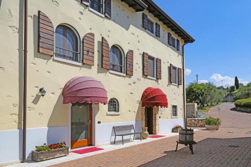 a building with red awnings on a street at Apartments Colombara Bardolino in Bardolino